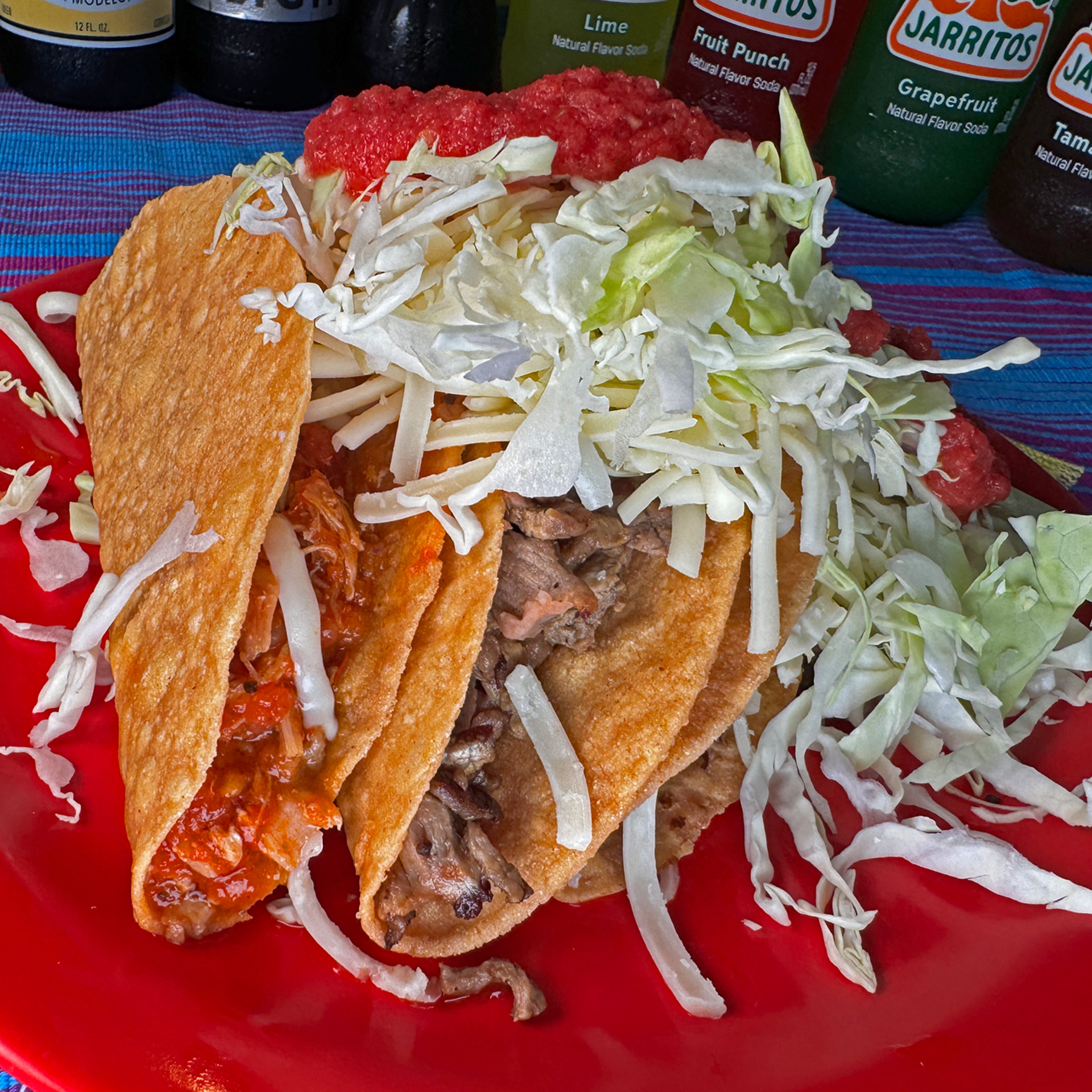 Crunchy golden tacos stuffed with shredded meat, topped with lettuce and cheese.